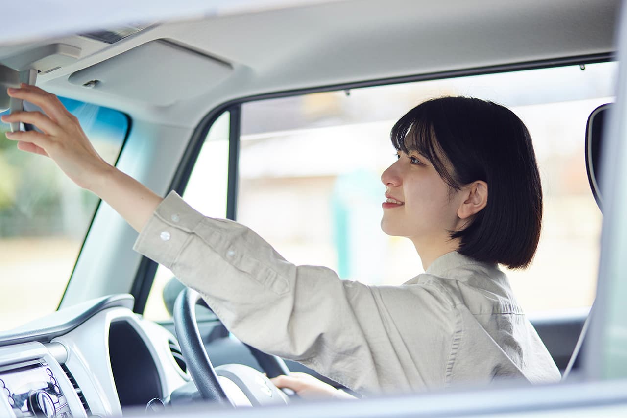 女性が車の中でミラーを確認している様子