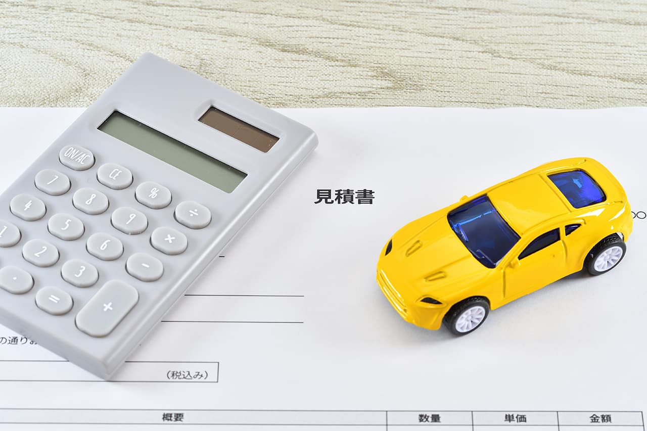 黄色いミニカーと電卓と見積書