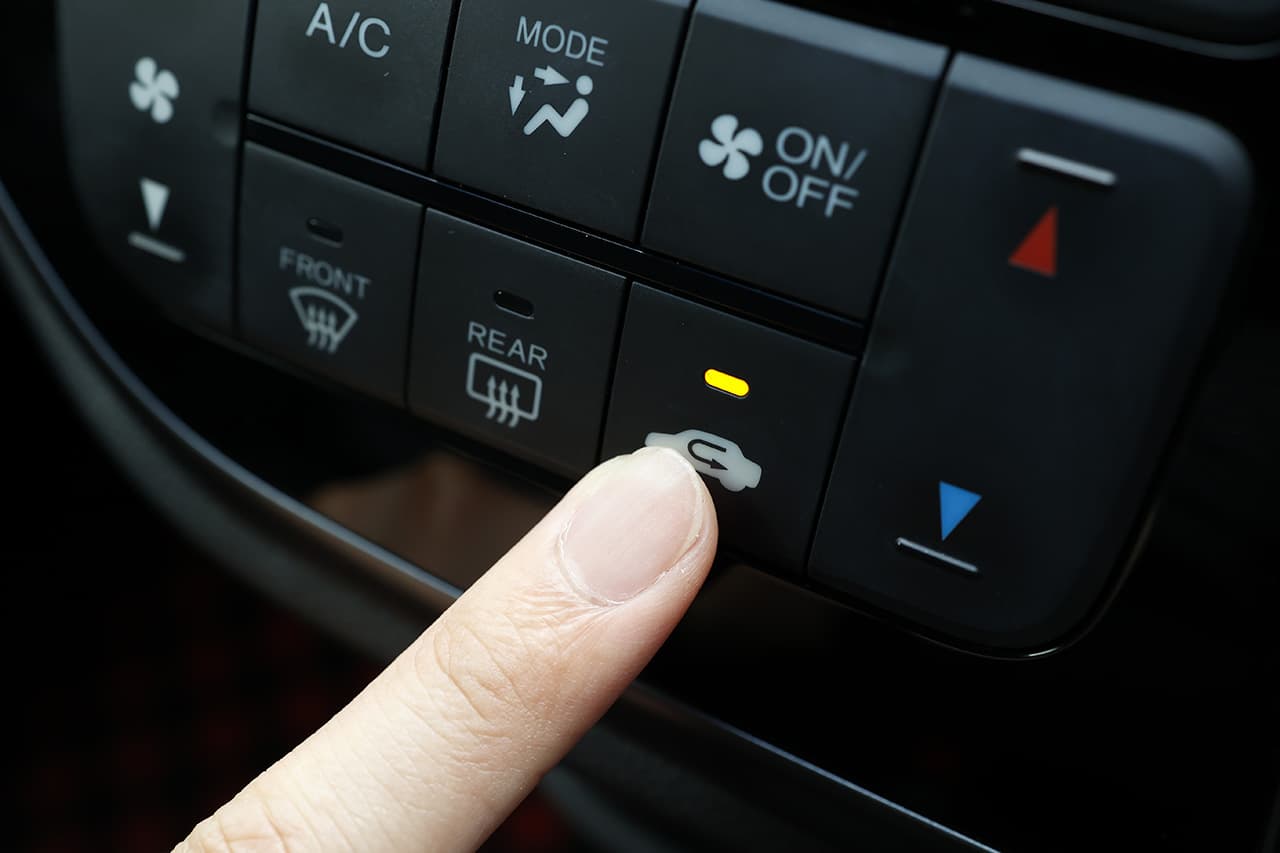 車のエアコンを押している様子